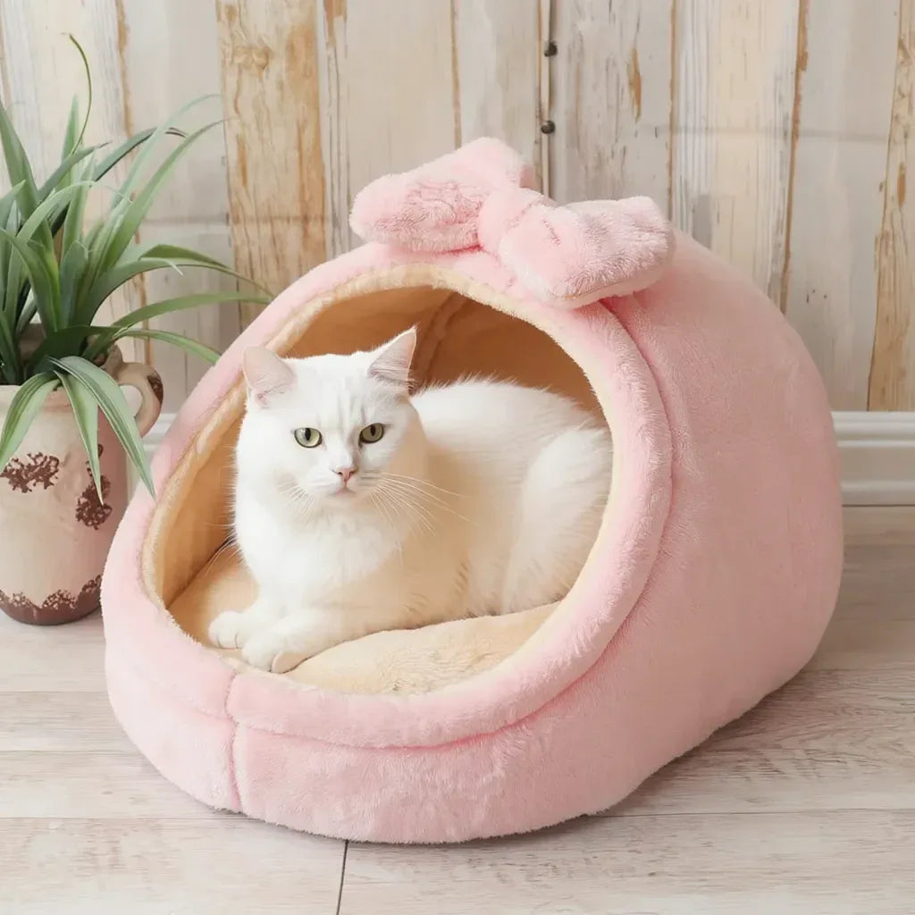 Gato dentro da cama para gatos rosa com detalhe lacinho no topo 