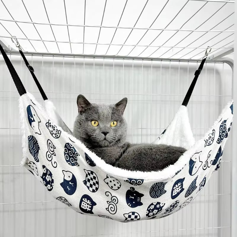 Gato com olhos bem abertos deitado em rede de cadeira suspensa para gatos